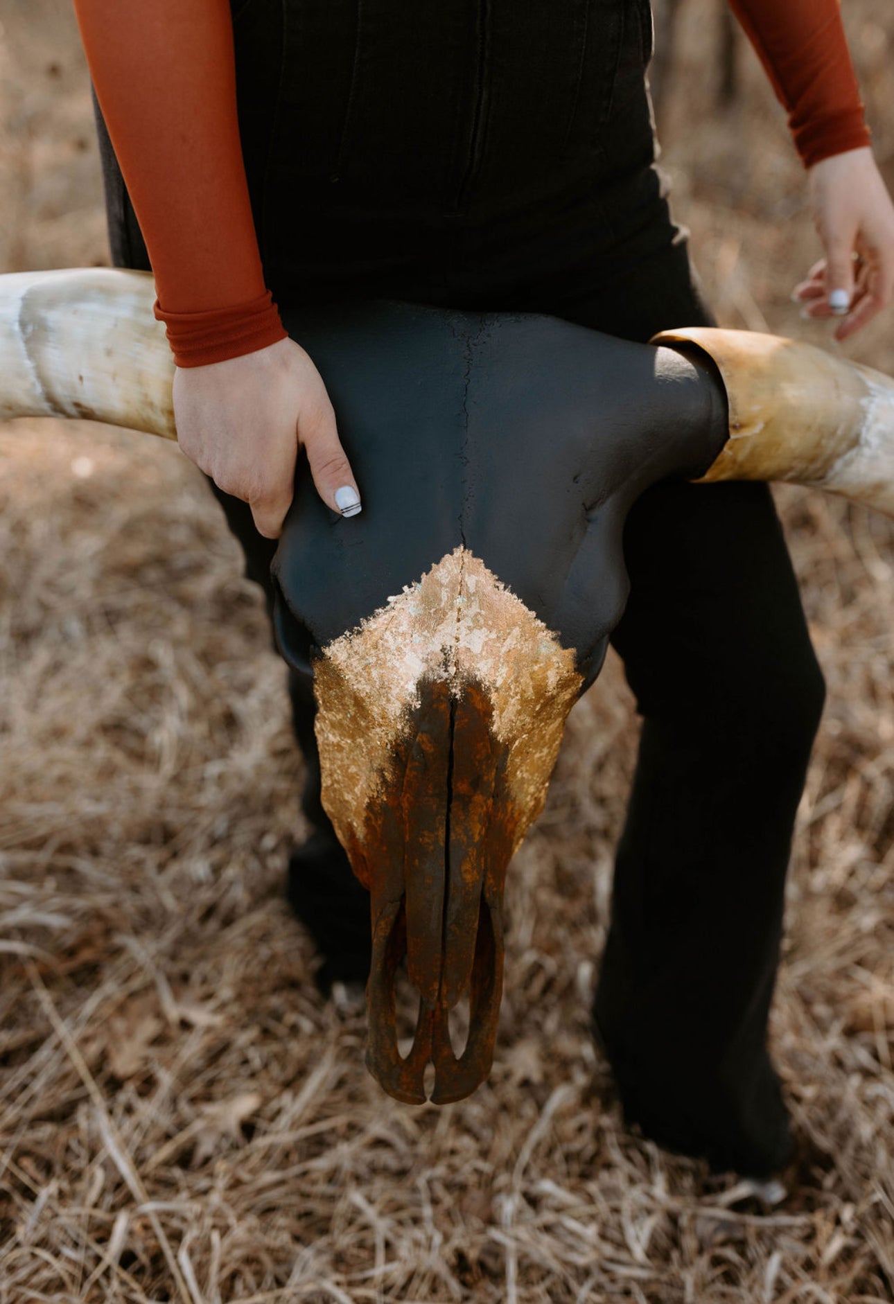 Matte black, gold, and rust finished longhorn cow skull painted by Wanderlust Skulls