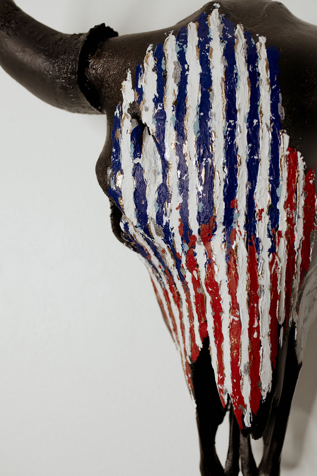 American buffalo skull with a painted American flag design on a white background